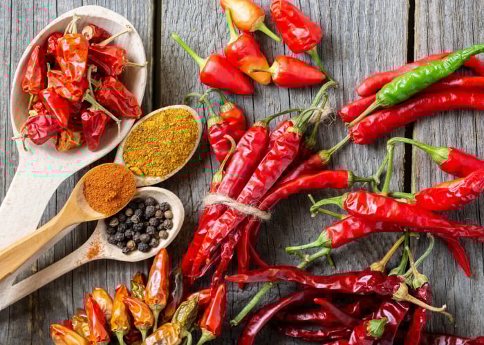 can dogs eat spicy food - a variety of chili peppers spread out on a wooden board